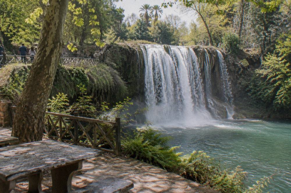 A river waterfall falling through a green inland park