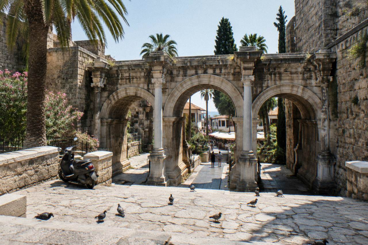 Stone archway of Hadrian's Gate in Antalya with old town streets beyond