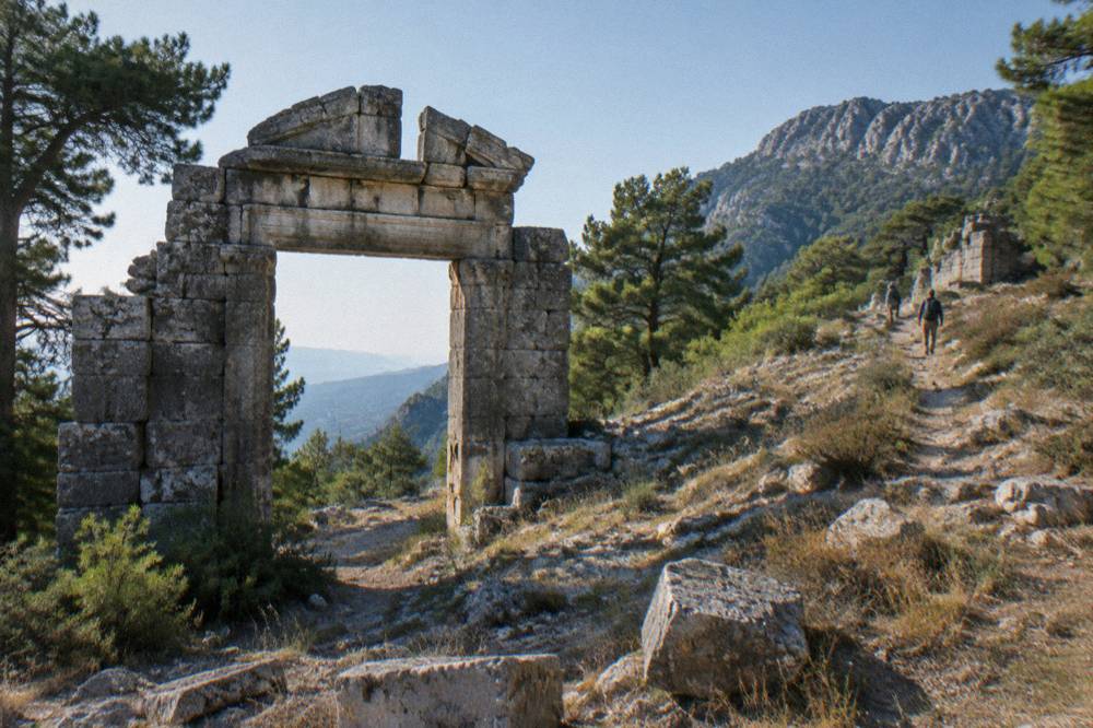 Stone ruins of an ancient city gate under a clear sky near Antalya