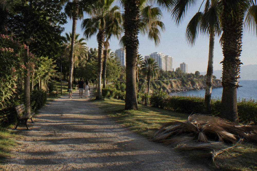A palm-lined street with hotel buildings in Antalya under a clear sky