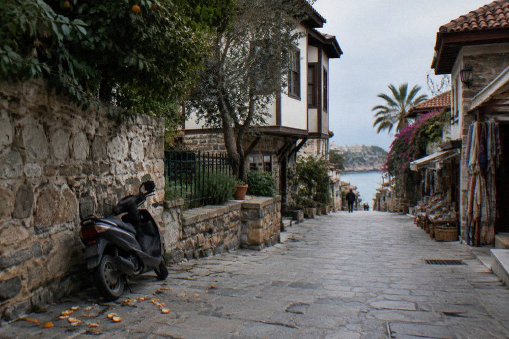 Old town lane in Kaleici with stone walls and parked street furniture