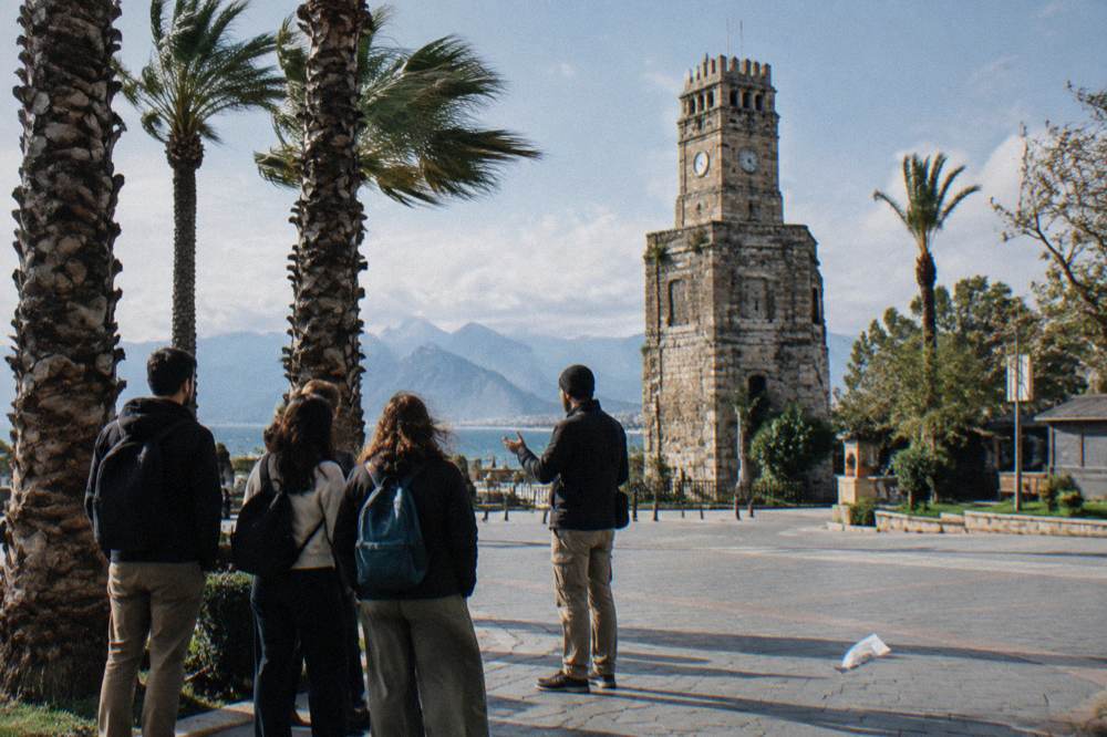Meeting point at an old stone gate in Antalya with a guide gathering a small group