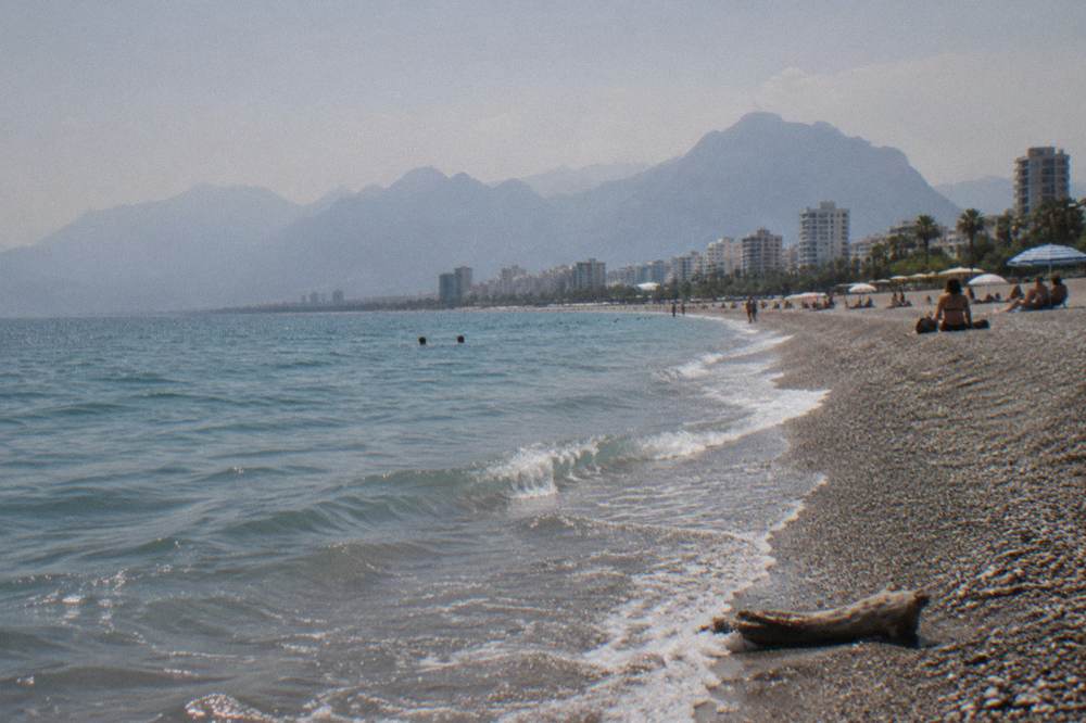 The Konyaalti coastline curving along the water with the city behind it