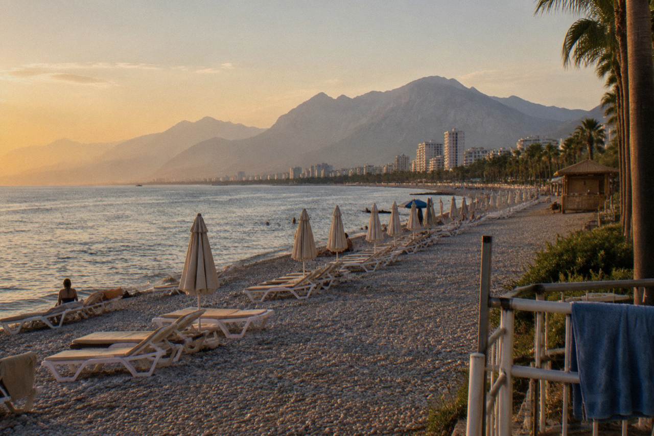 The long Konyaalti coastline with rows of sun loungers and calm sea along the shore