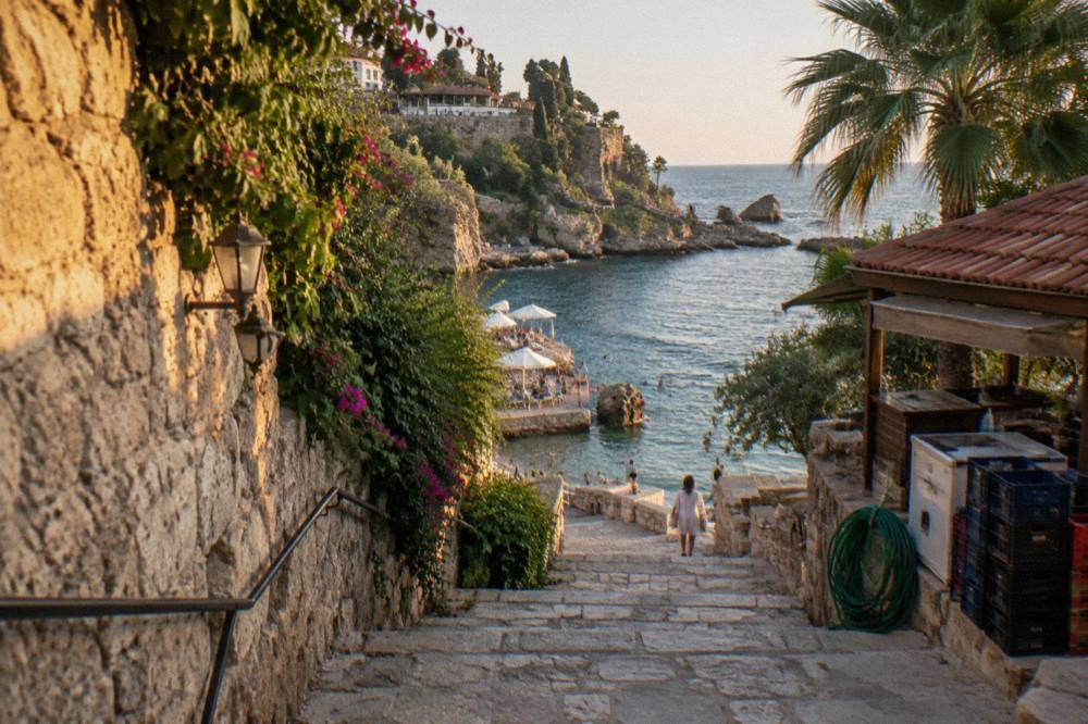 A coastal promenade in Antalya with an open sky above the water