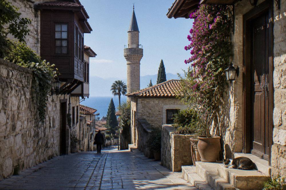 Narrow Kaleici street with stone houses and a mosque minaret above the rooftops