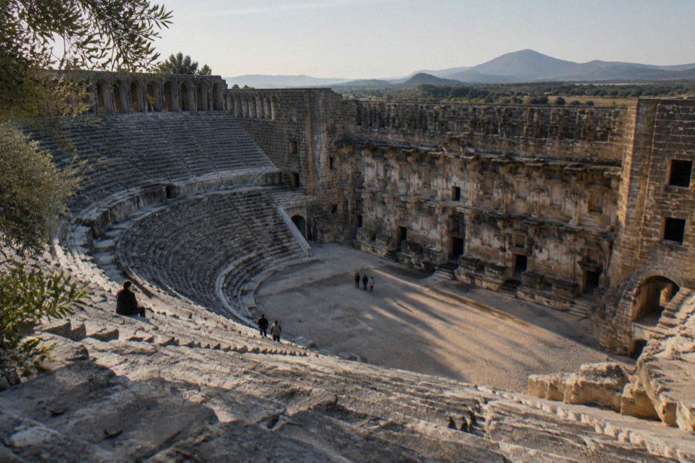 Rows of stone seats in an ancient theatre under open sky