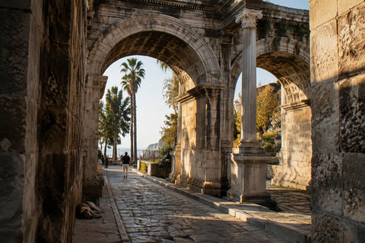 Old town stone archway with Roman columns and narrow street in Antalya