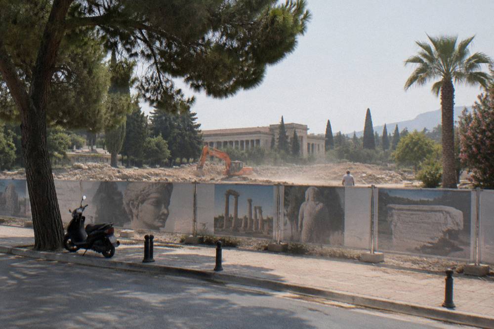 A cleared building site behind hoarding in a Mediterranean city