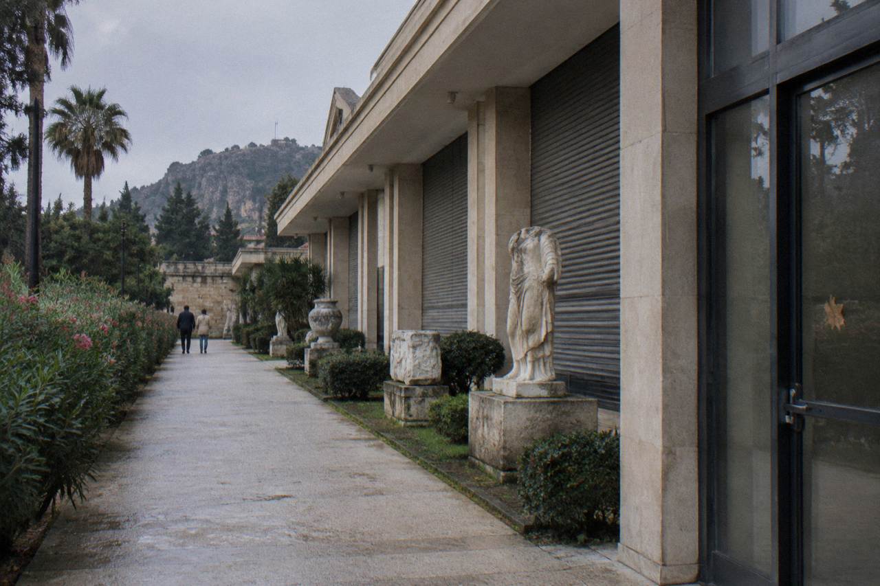 A closed museum building beside a garden path in Antalya