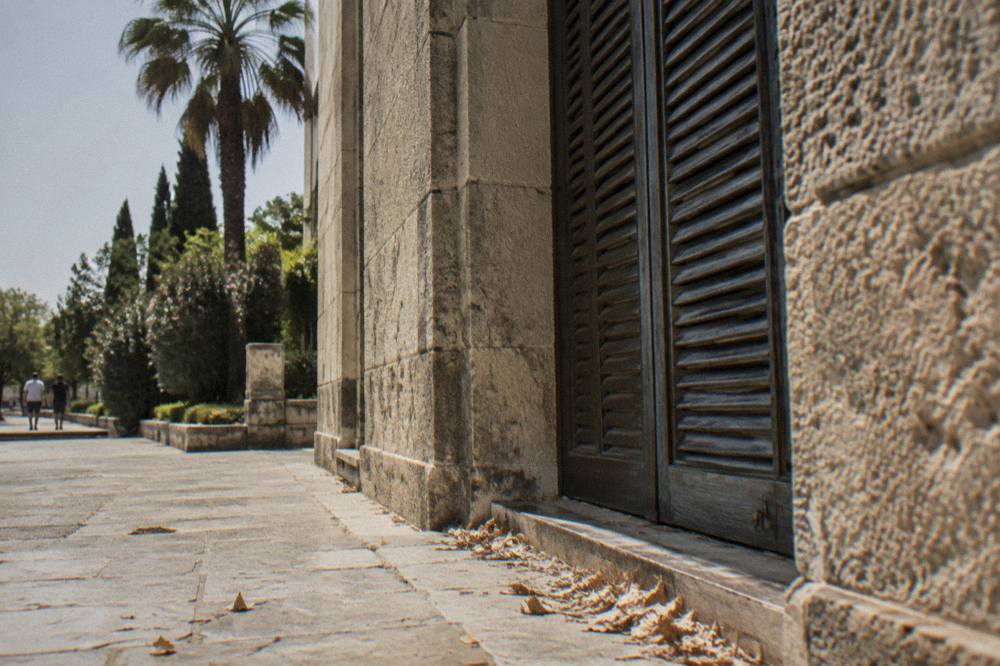 A closed museum entrance with shuttered doors and a stone facade in Antalya