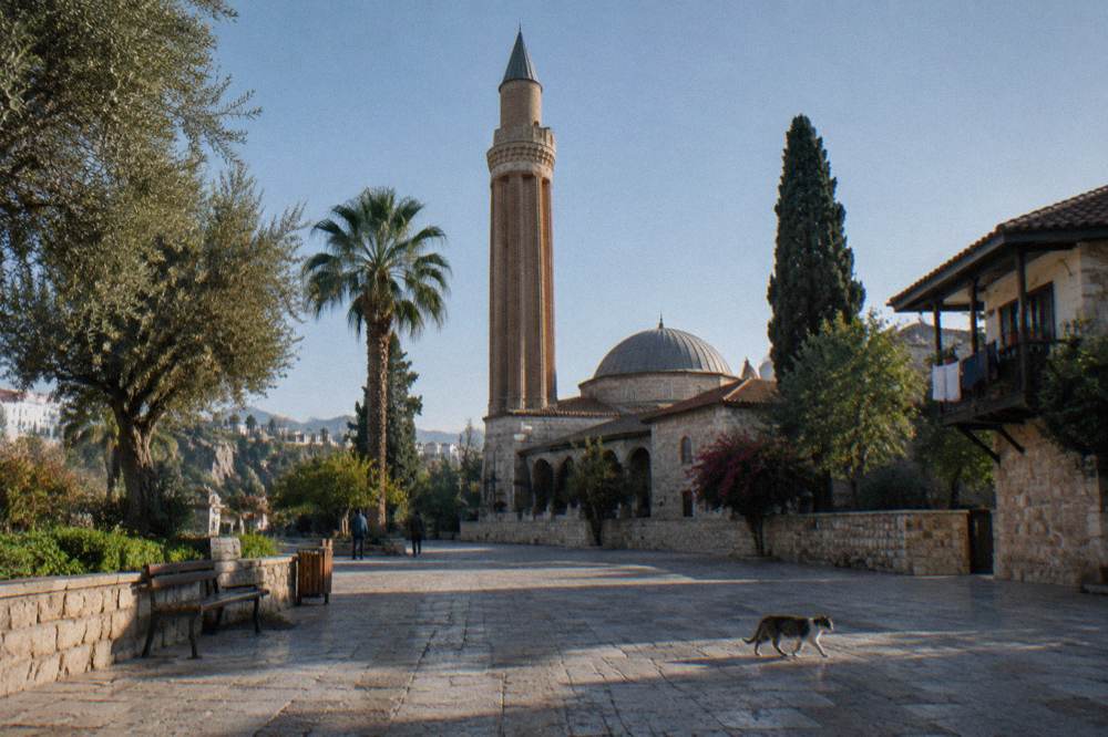 A stone minaret complex in Antalya old town under a clear sky