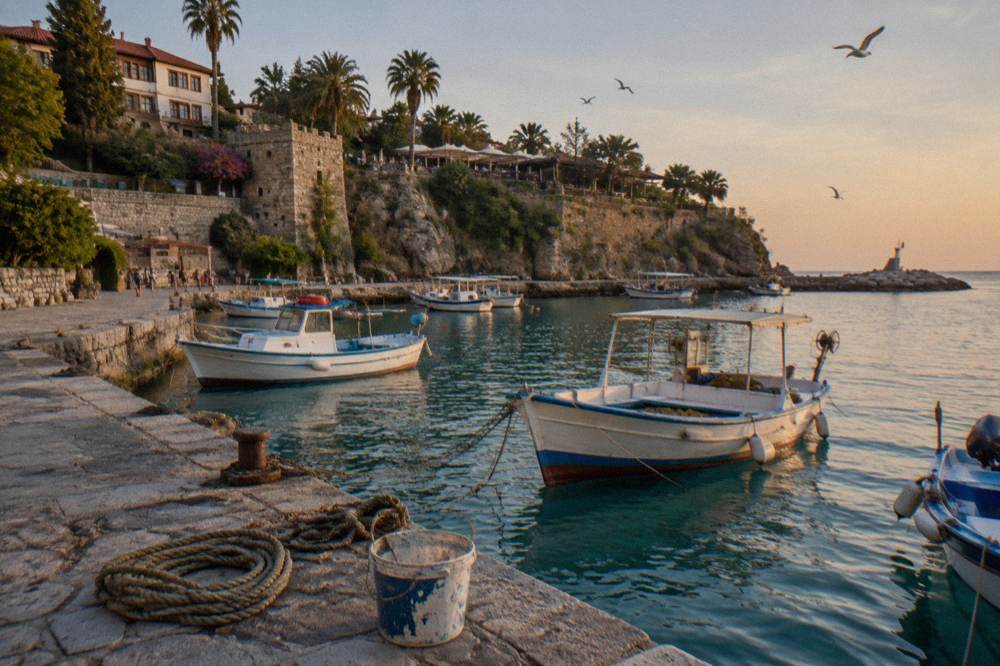 Old harbour waterfront with stone quay and moored boats
