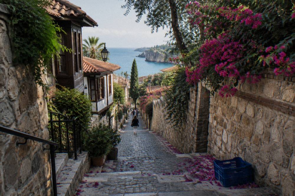 Old town lane curving between stone walls toward the sea