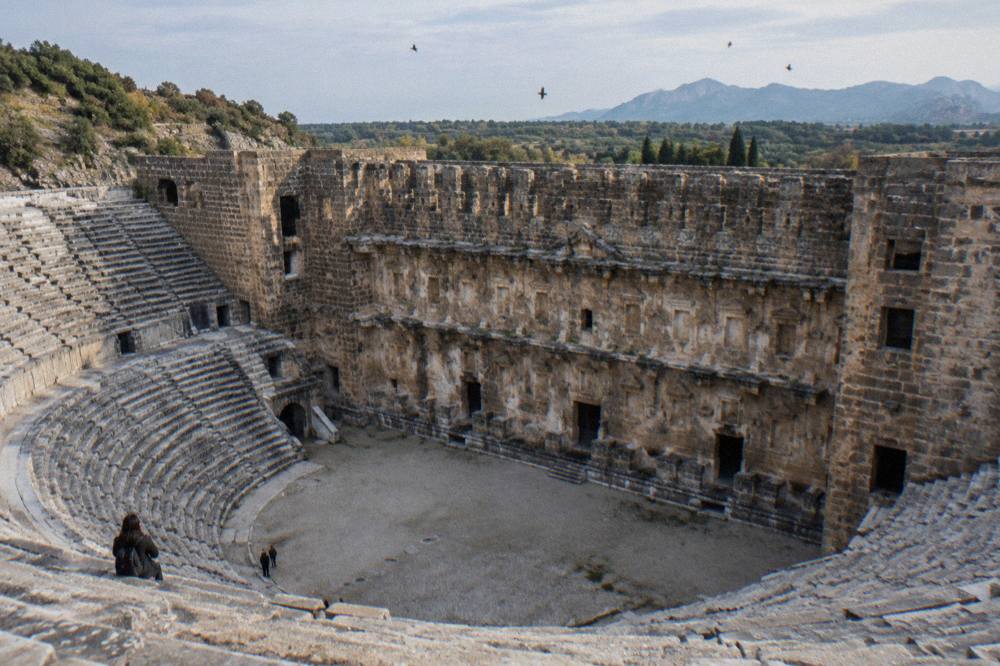The tall stone stage wall of the Aspendos theatre seen from the seating
