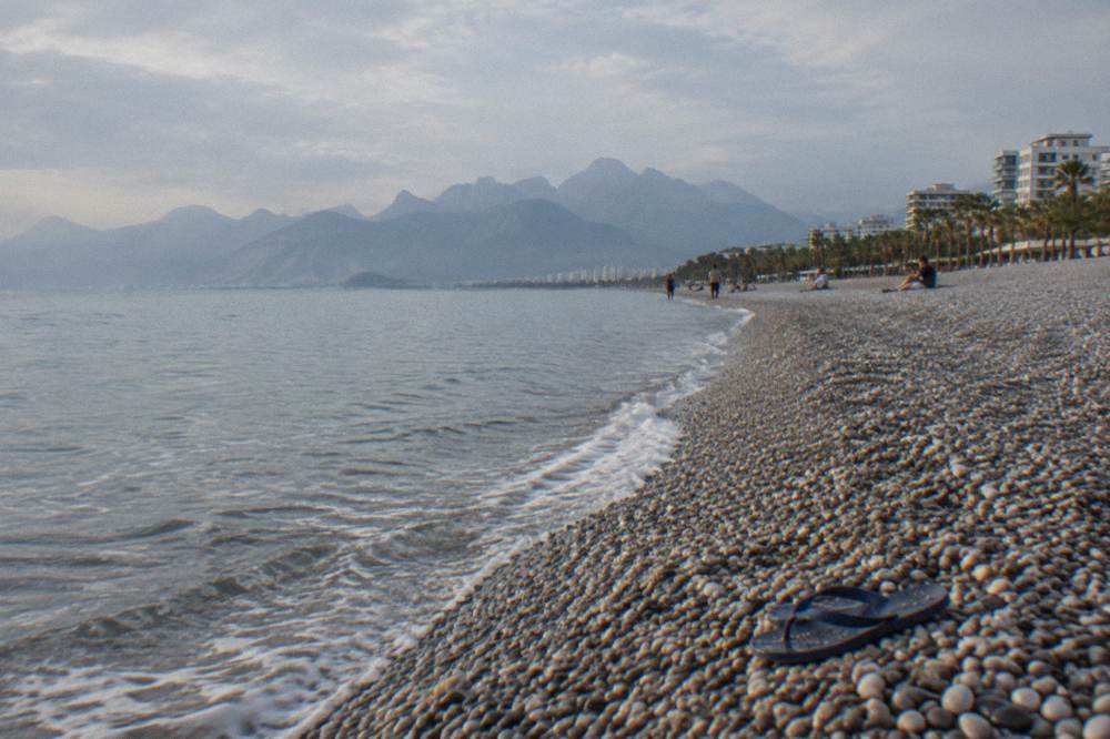 Long curving coastline with a pebble beach and calm water at Antalya