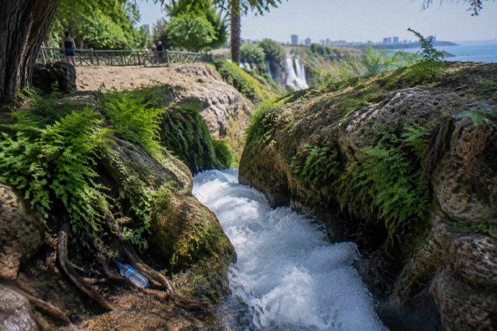A wide waterfall flowing through a rock channel in a park