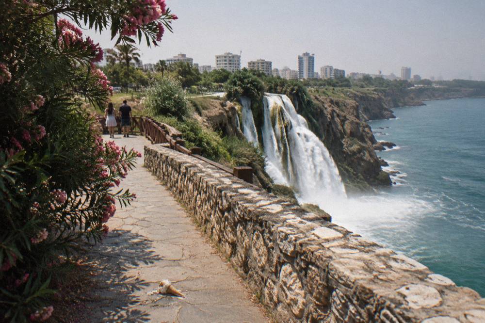 A cliff-top park path above a waterfall