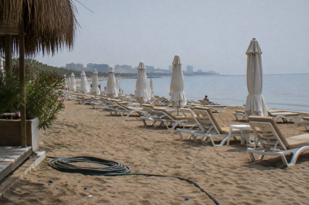 Rows of sunbeds and umbrellas on a private beach club beside the sea