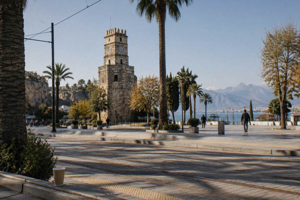 A stone clock tower beside a square in central Antalya