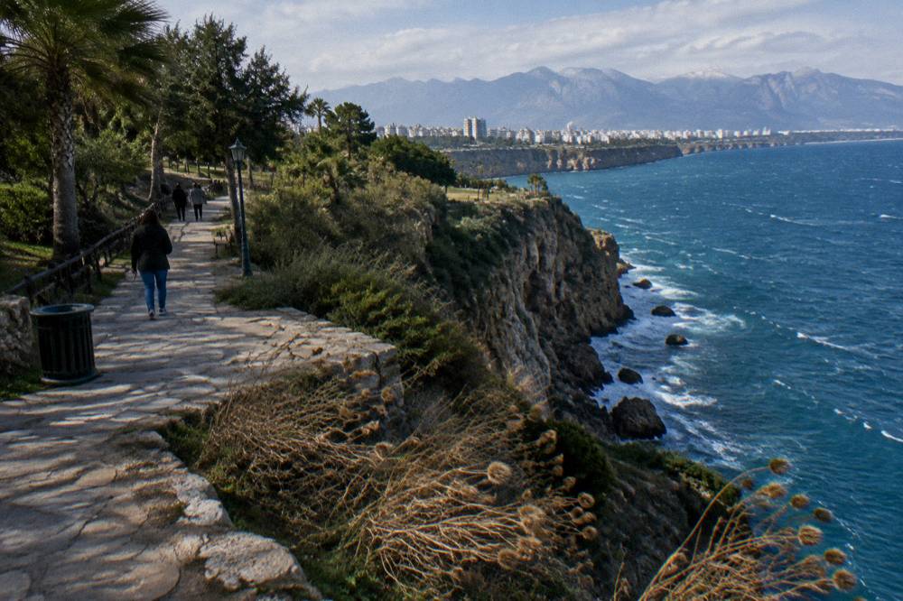 A cliff-top stone path above a rocky coastline with sea below