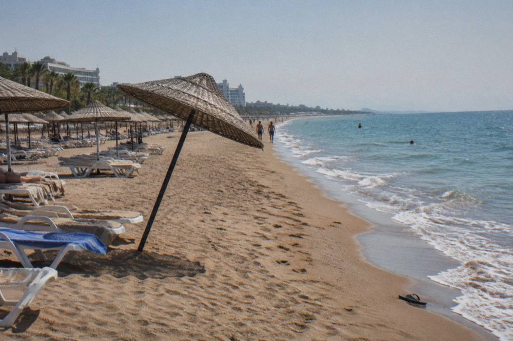 Long sandy beach on the Lara coast with sun loungers in rows and the sea beyond