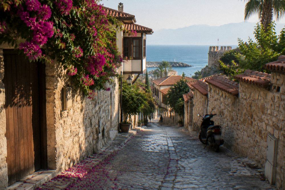 Narrow old town street with stone buildings leading toward the sea